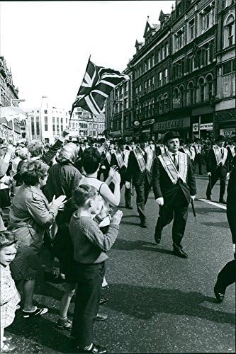 Vintage fotografija grupe ljudi koji marširaju kao gledaoci navijajući se.